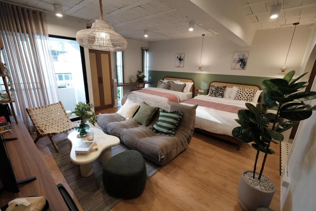 バンコクにあるThe Shantipan Jasmine - Cozy City Retreat 400m from BTS Stationのベッド2台とソファのあるリビングルーム