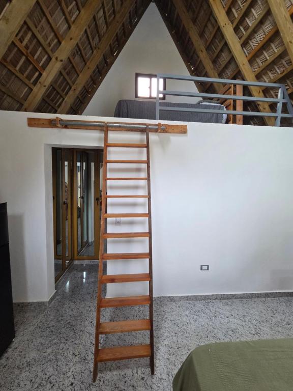 a ladder leading up to a bunk bed in a room at Charming Bungalow with Pool in Sosúa