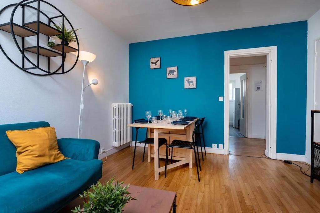 un soggiorno blu con tavolo e parete blu di Appartement 3 chambres Wifi Lorient Centre a Lorient