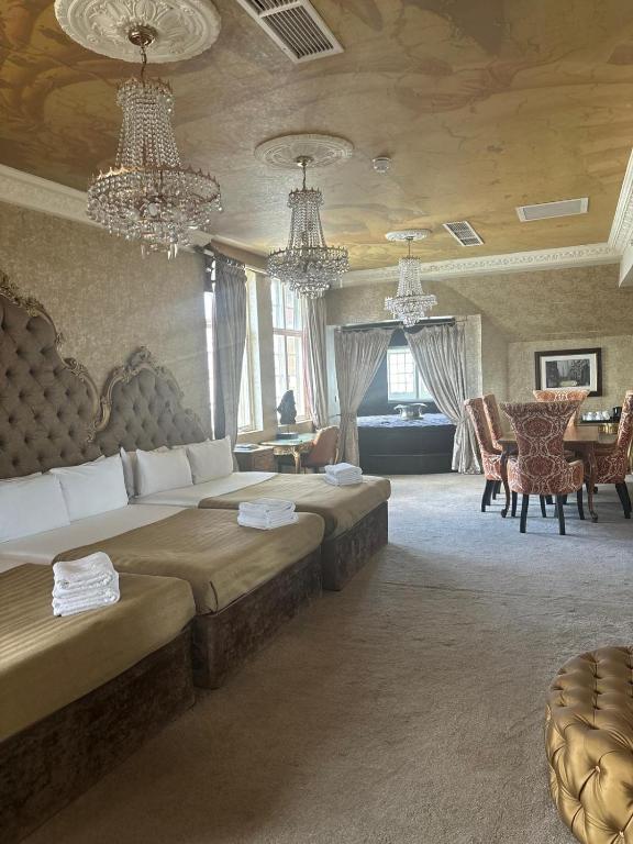 a large room with two beds and a table and chairs at White Star Line Hotel in Liverpool