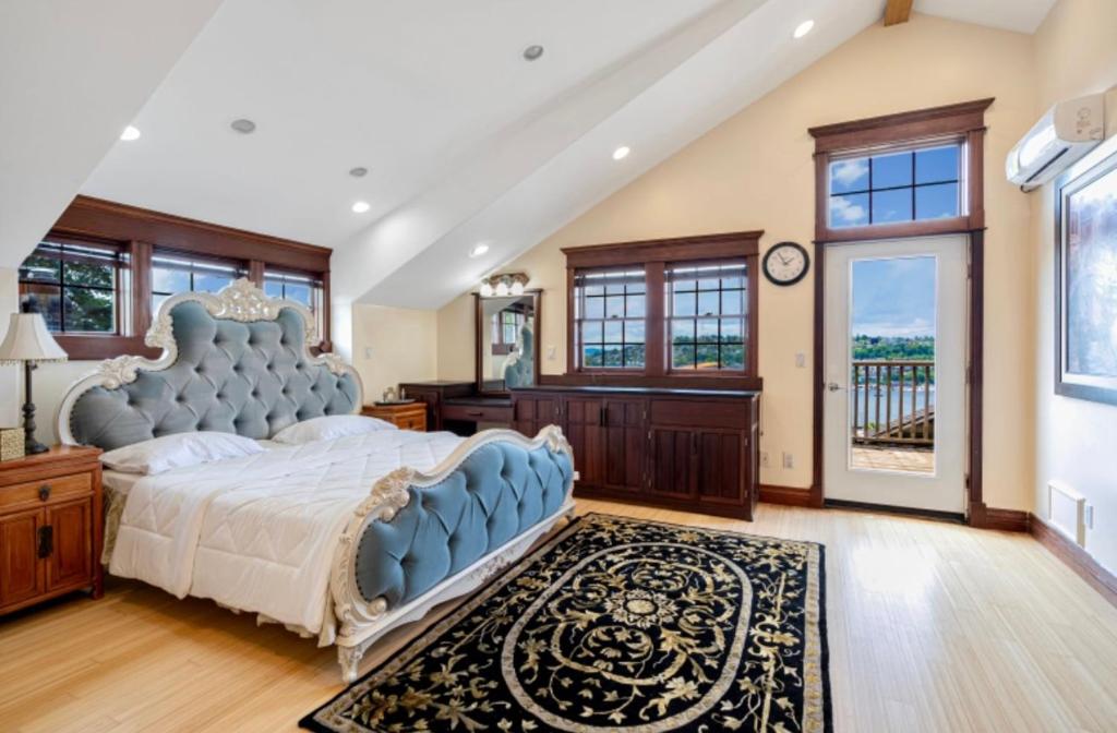 une chambre avec un grand lit avec une tête de lit bleue dans l'établissement Emerald water vila in capital hill, à Seattle