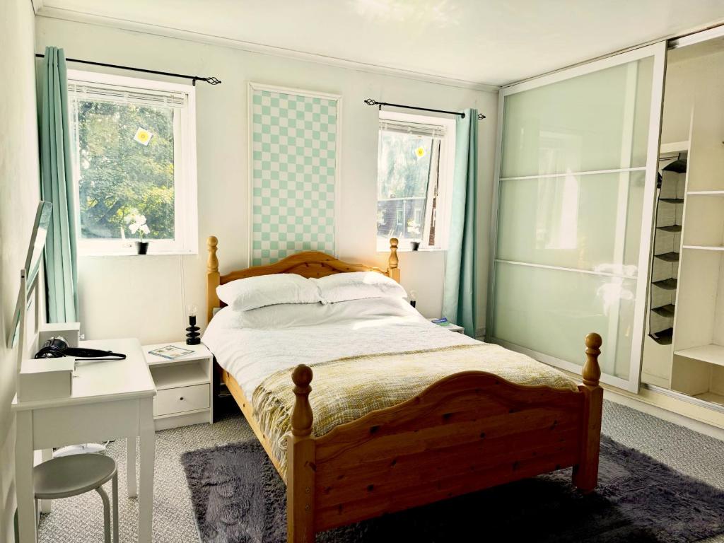 ein Schlafzimmer mit Bett, Schreibtisch und Fenstern in der Unterkunft No23 - Bright & spacious 2nd floor flat - PET friendly - Noon check out in Stanwix