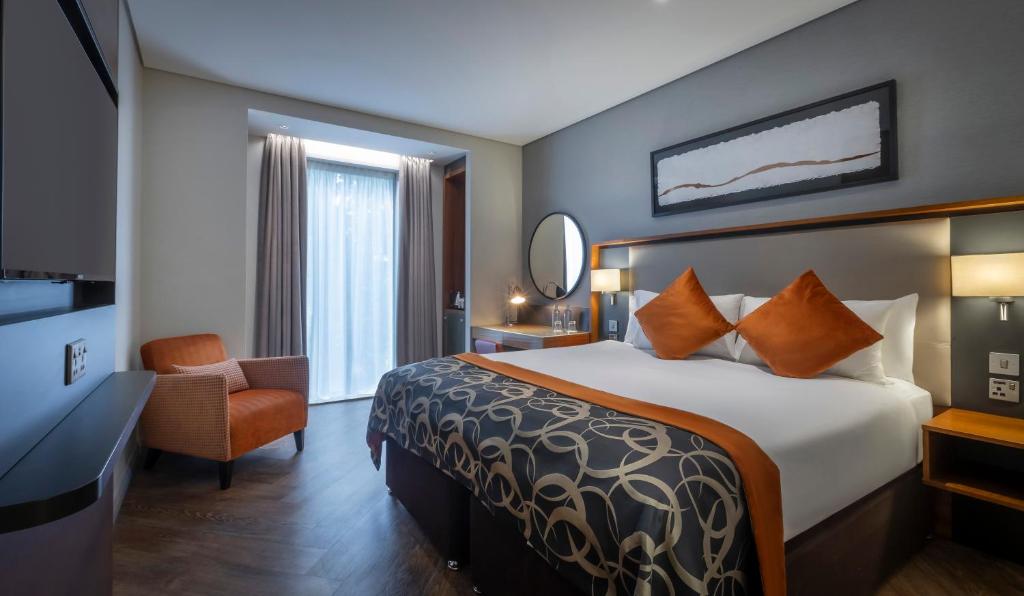 a hotel room with a bed and a chair at Clayton Hotel Birmingham in Birmingham