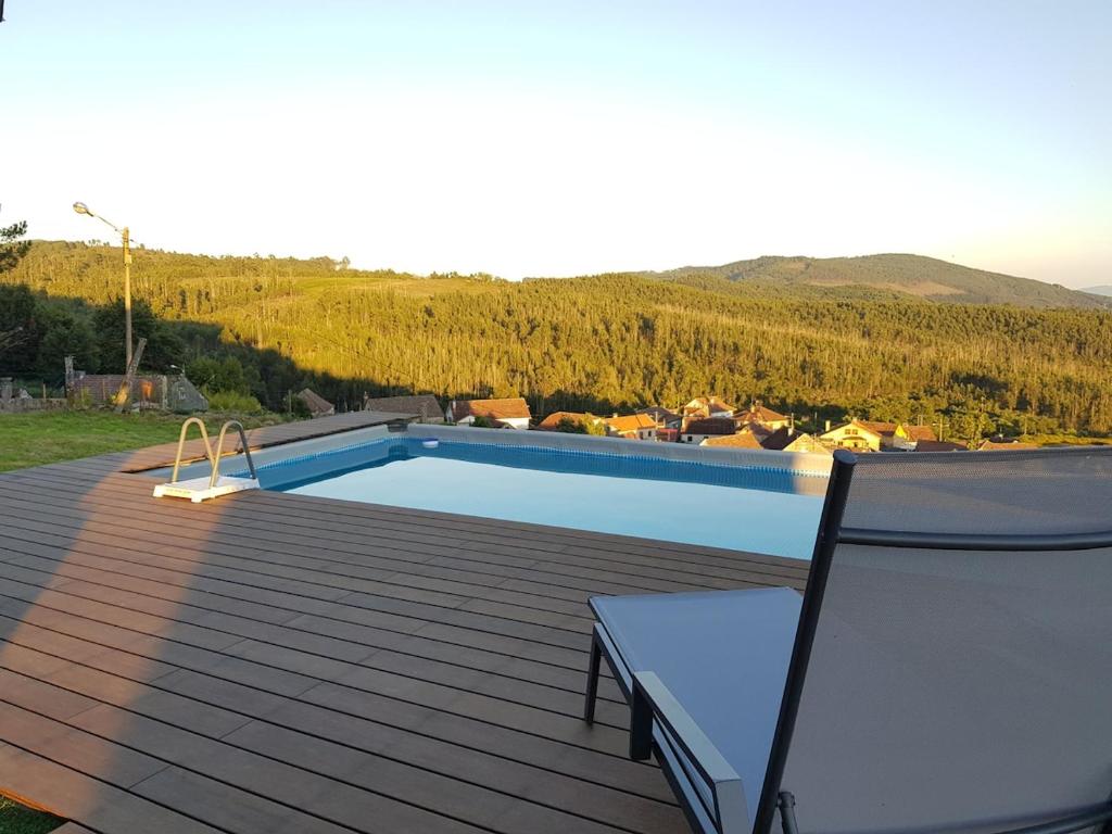 a swimming pool on top of a wooden deck at Casa Esmeralda in Borbén