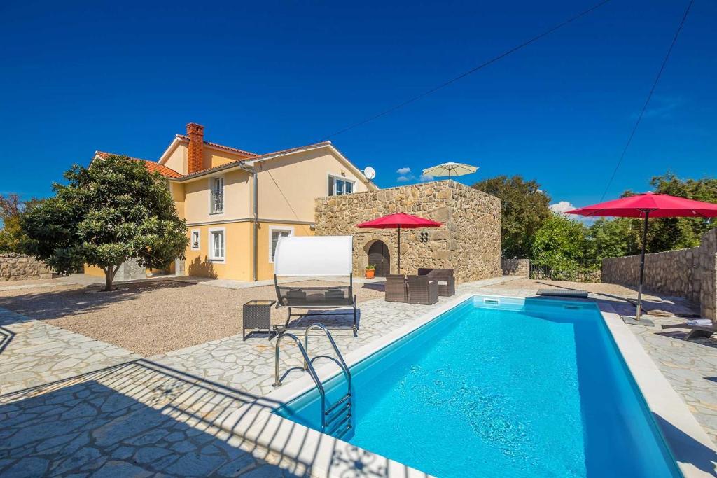a swimming pool in front of a house at Villa Mediteran with private pool in Vrh