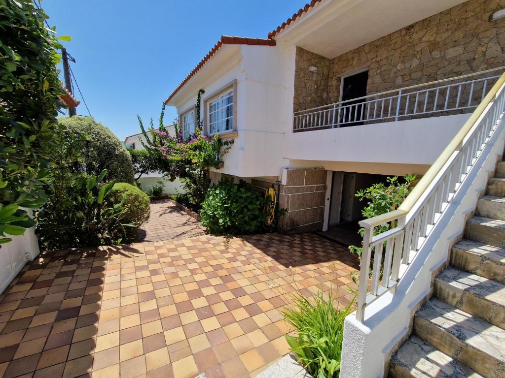 a house with stairs leading up to it at Casa en la playa de Panxón in Nigrán