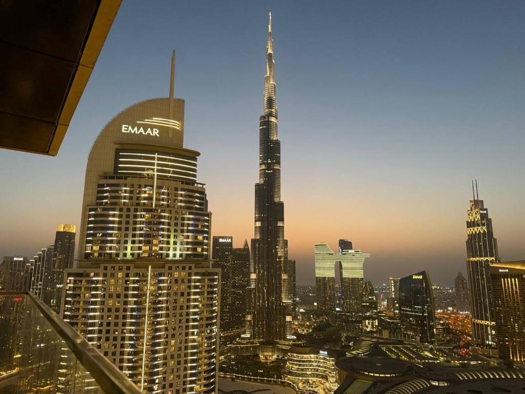 une vue de la ville la nuit avec le bâtiment Burj dans l'établissement เพ้นท์เฮ้าส์ Boulevard - Point Downtown Dubai, à Dubaï