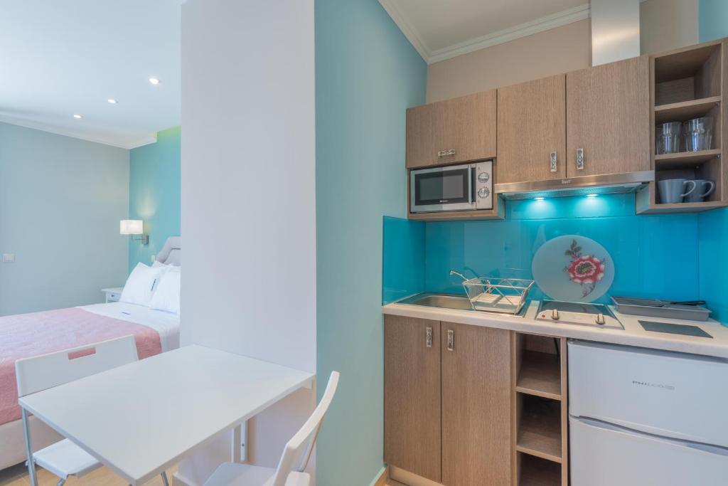 a small kitchen with a table and a bed at Pansion Ermioni in Skala