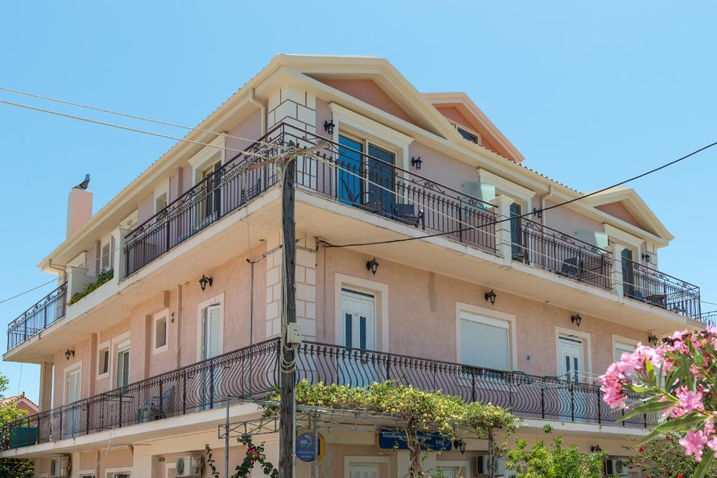 an apartment building with balconies and flowers at Pansion Ermioni in Skala
