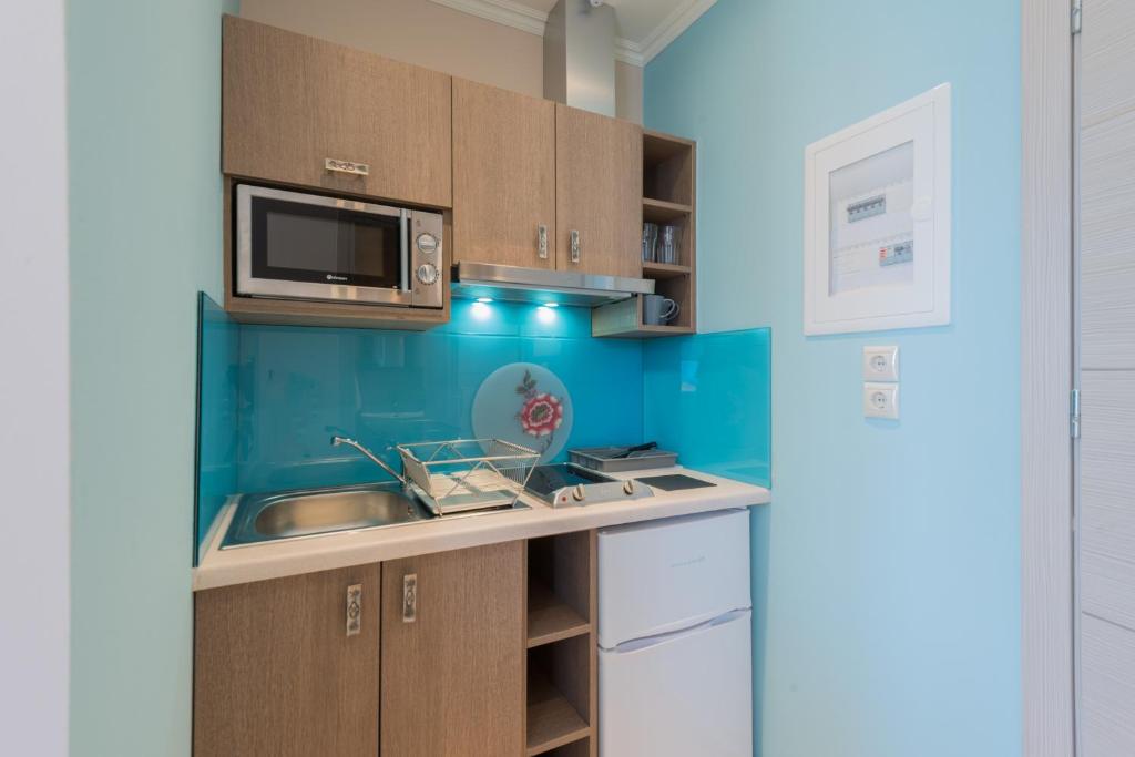 a kitchen with a sink and a microwave at Pansion Ermioni in Skala