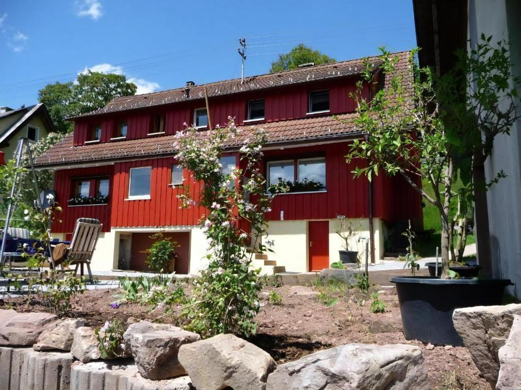 a red house with a tree in front of it at Ferienhaus Elfi in Oberbränd