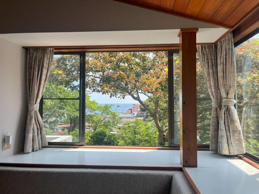 una grande finestra in un soggiorno con vista di Sotoura Resort House 涛Tõ! BBQ-MAX10ppl-4min to Sotoura beach! a Shimoda