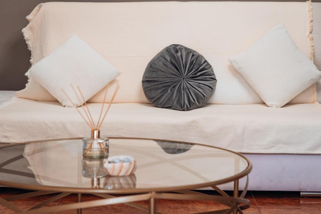 a white couch with pillows and a glass table at Luxury Suite Prada in Paleokastritsa