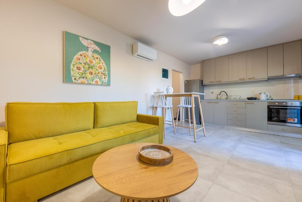 a living room with a yellow couch and a table at Azure Sofia - Grounded in Kos