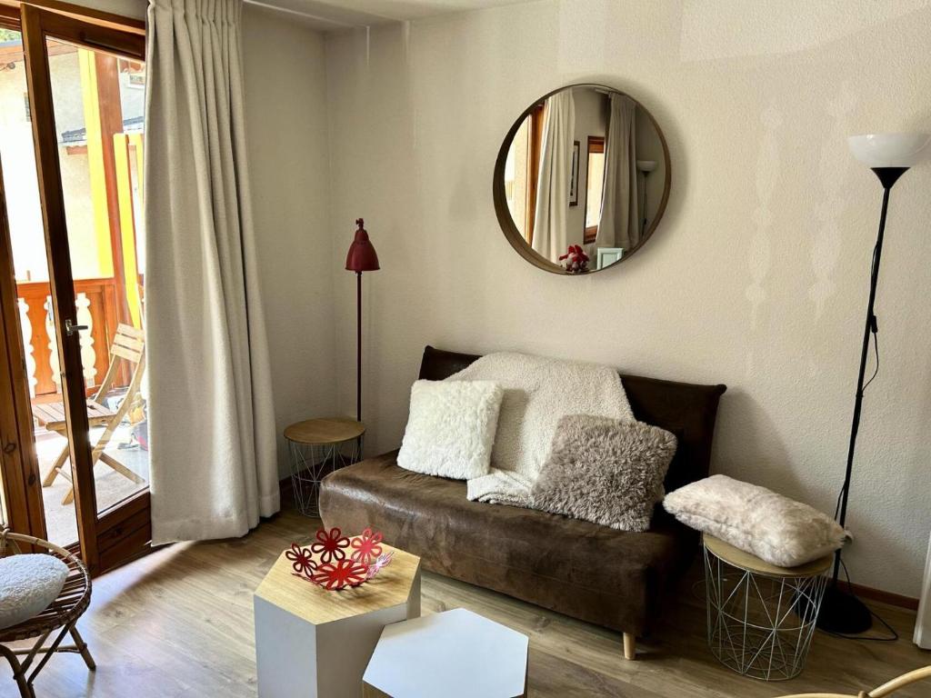 a living room with a couch and a mirror at Résidence Les Essarts - 3 Pièces pour 6 Personnes MAE-2053 in Lanslevillard