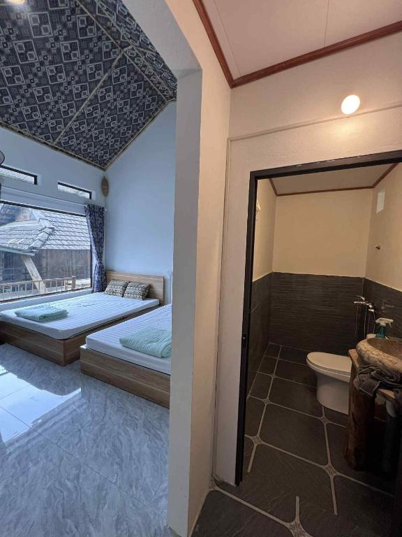 a bedroom with a bed and a bathroom with a toilet at Ume Homestay in Mai Châu