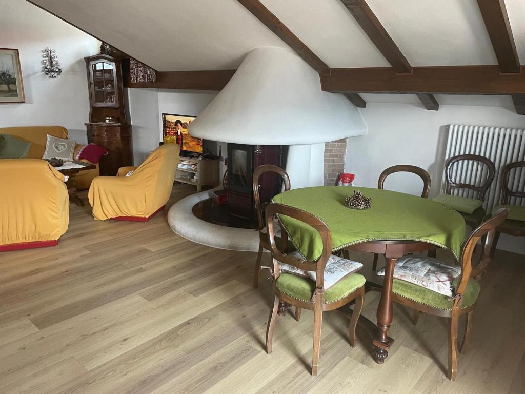 a living room with a table and a fireplace at Mansarda Cadore in Pieve di Cadore