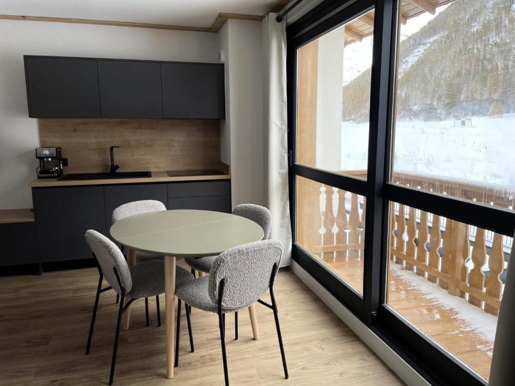 a kitchen with a table and chairs next to a window at Résidence Cokott - 2 Pièces pour 4 Personnes MAE-2573 in Bessans