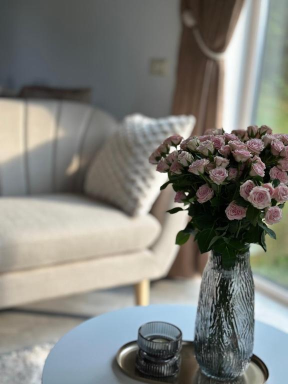 a vase of pink flowers sitting on a table at Field house in Slavske