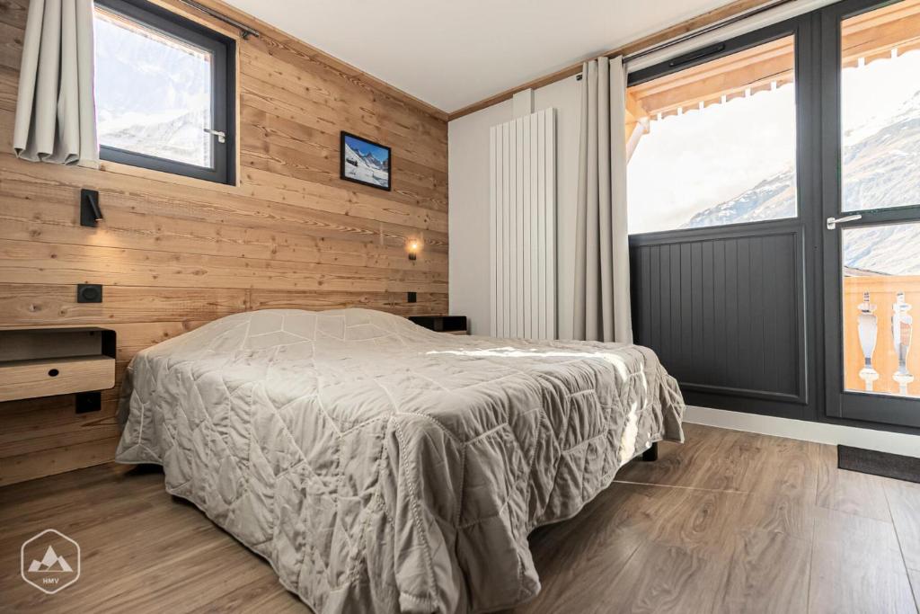 a bedroom with a bed in a room with windows at Résidence Cokott - 2 Pièces pour 4 Personnes MAE-2603 in Bessans