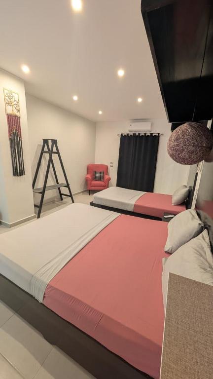 ein Schlafzimmer mit zwei Betten und einem roten Stuhl in der Unterkunft Hostify Hostel and Rooftop in Hurghada