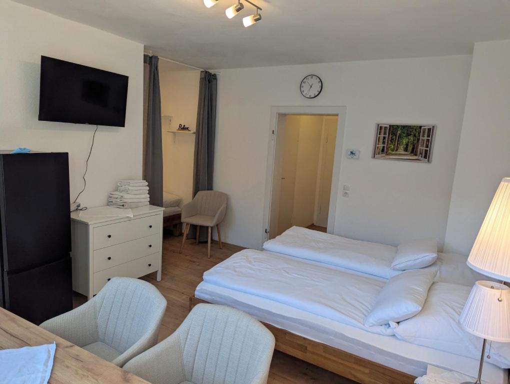 1 dormitorio con 1 cama, 2 sillas y reloj en City Apartment - Heinrich der Löwe - City Center - Keybox - 3 Persons, en Brunswick
