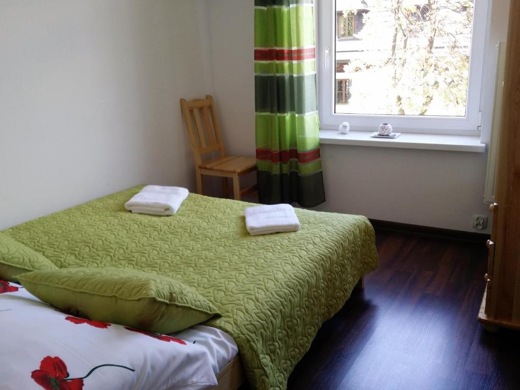 ザコパネにあるApartament Giewont Krupowkiのベッドルーム1室(ベッド1台付)、窓が備わります。