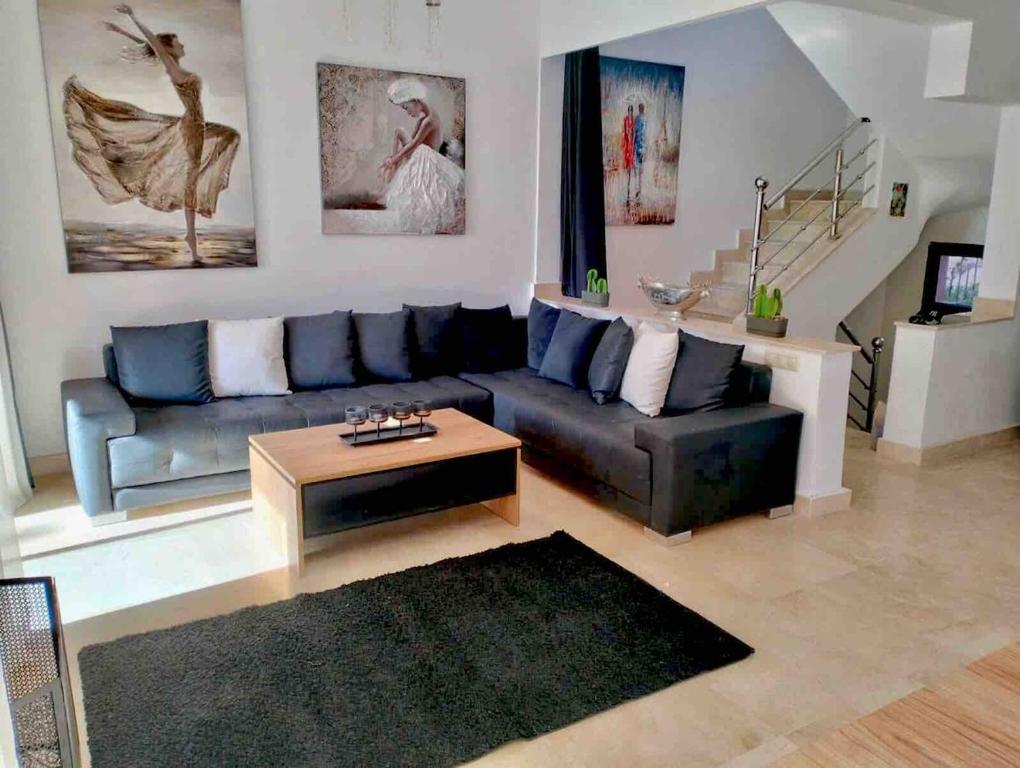 a living room with a couch and a coffee table at Pavillon Luxe - Jardin de l'Atlas - Golf & Waky in Sraghna