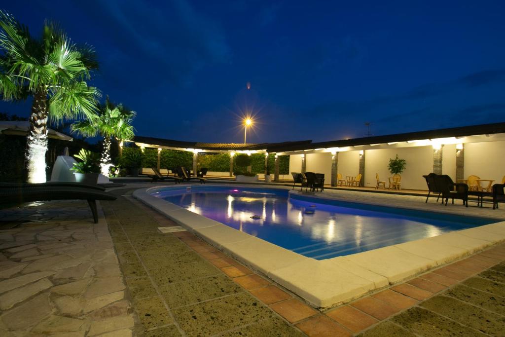 a swimming pool at night with a resort at Hotel la Fenice in Boscoreale
