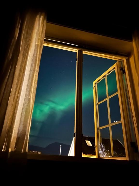 an open window with a view of the northern lights at Hybelleilighet - Privat - no parking in Tromsø