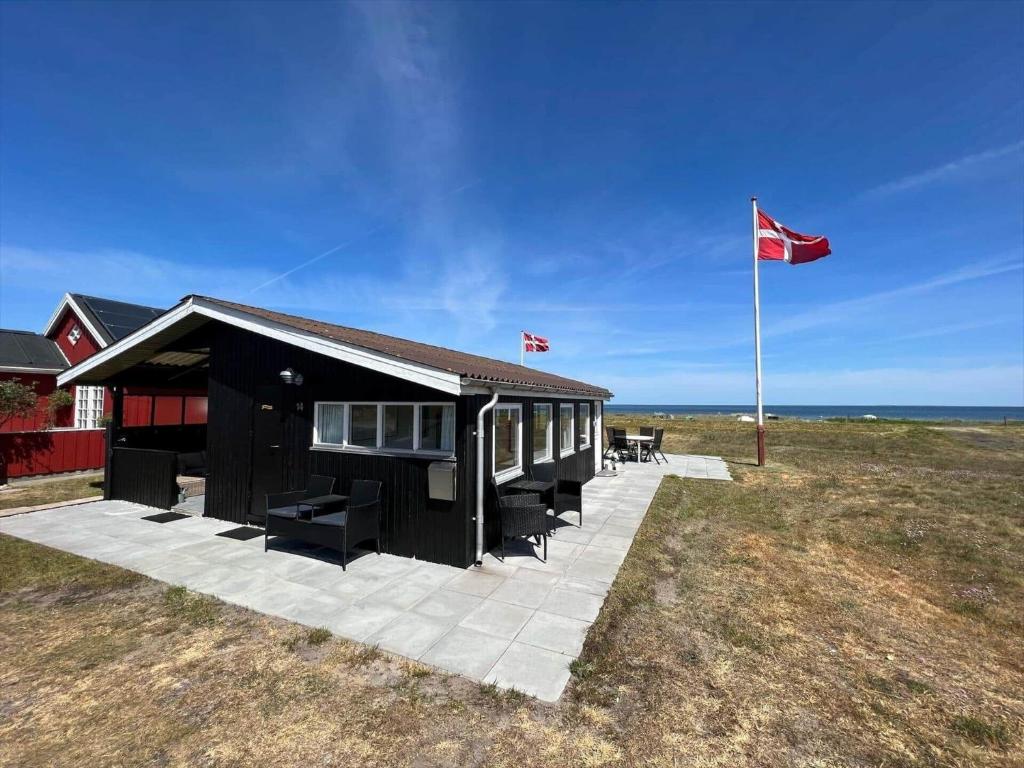 a small building with a flag and a flag pole at 40314-Juelsminde-Asbo-14 in Sønderby