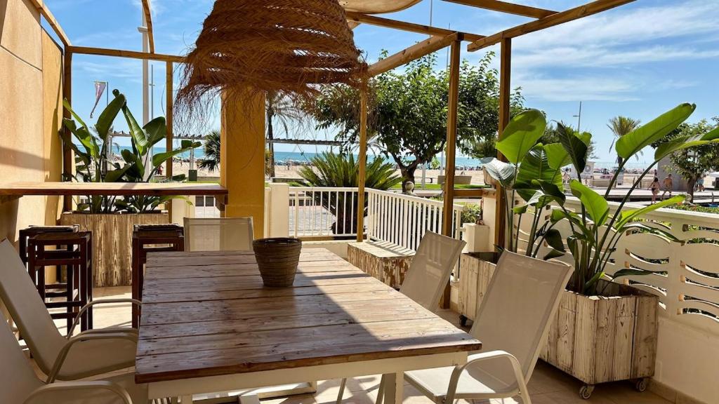 a wooden table and chairs on a patio at BeachFront Apartment in Gandia in Puerto de Gandía