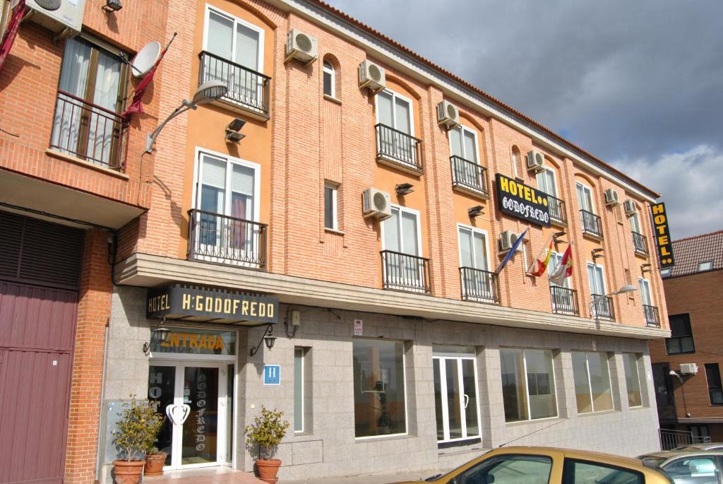 un gran edificio de ladrillo en una calle de la ciudad en Hotel Godofredo, en Toledo