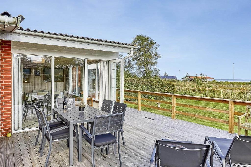 un patio con tavolo e sedie su un ponte di 30579-Odder-Dyngby-Havvej-5 a Odder