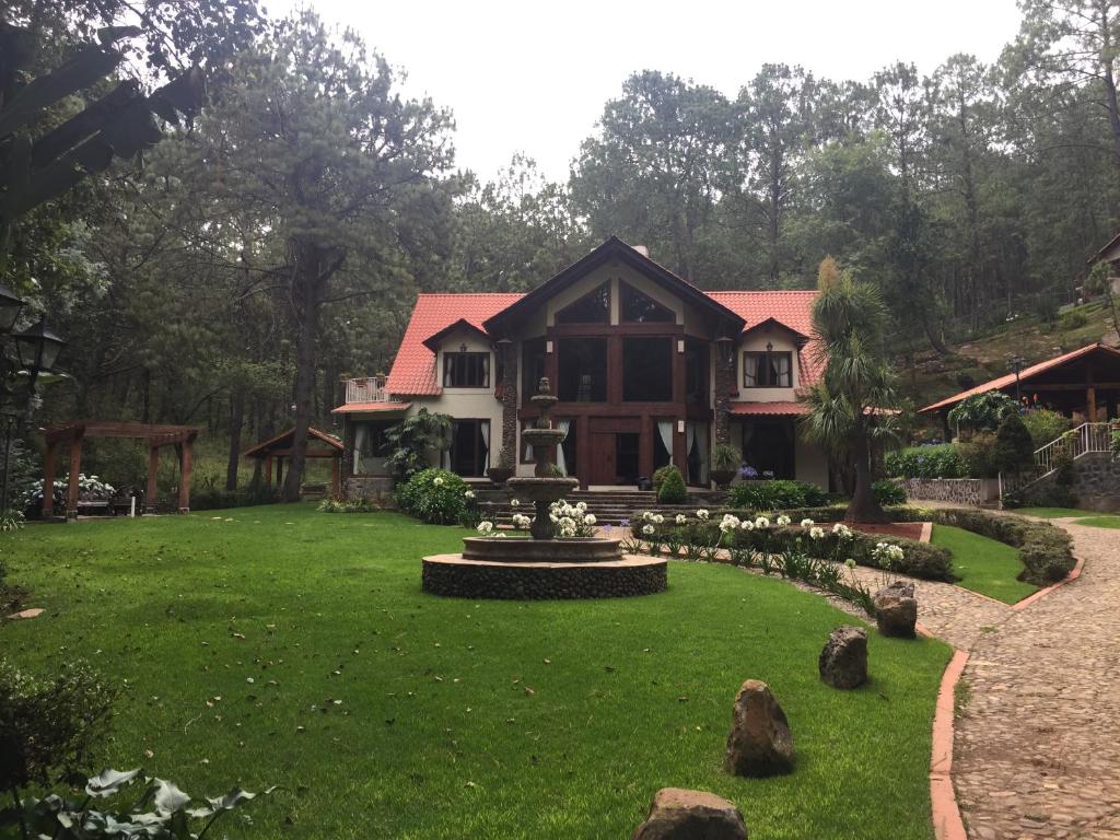 a house with a green lawn in front of it at Cabaña del RIO by Bellavista Cabañas in Mazamitla