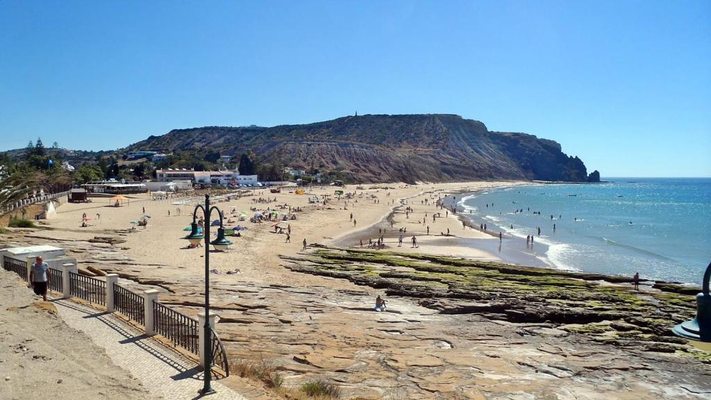 a group of people on a beach near the ocean at Vilamar in Luz