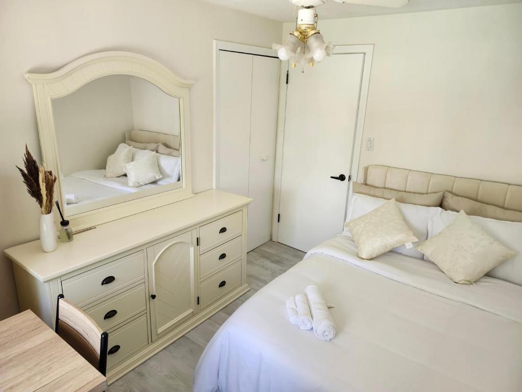 a bedroom with two beds and a mirror at 3Q Ltd in Hamilton