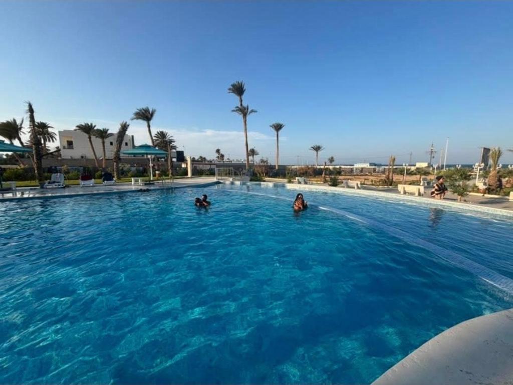 two people swimming in a large swimming pool at Diar el bahar zarzis sonia marina in Zarzis