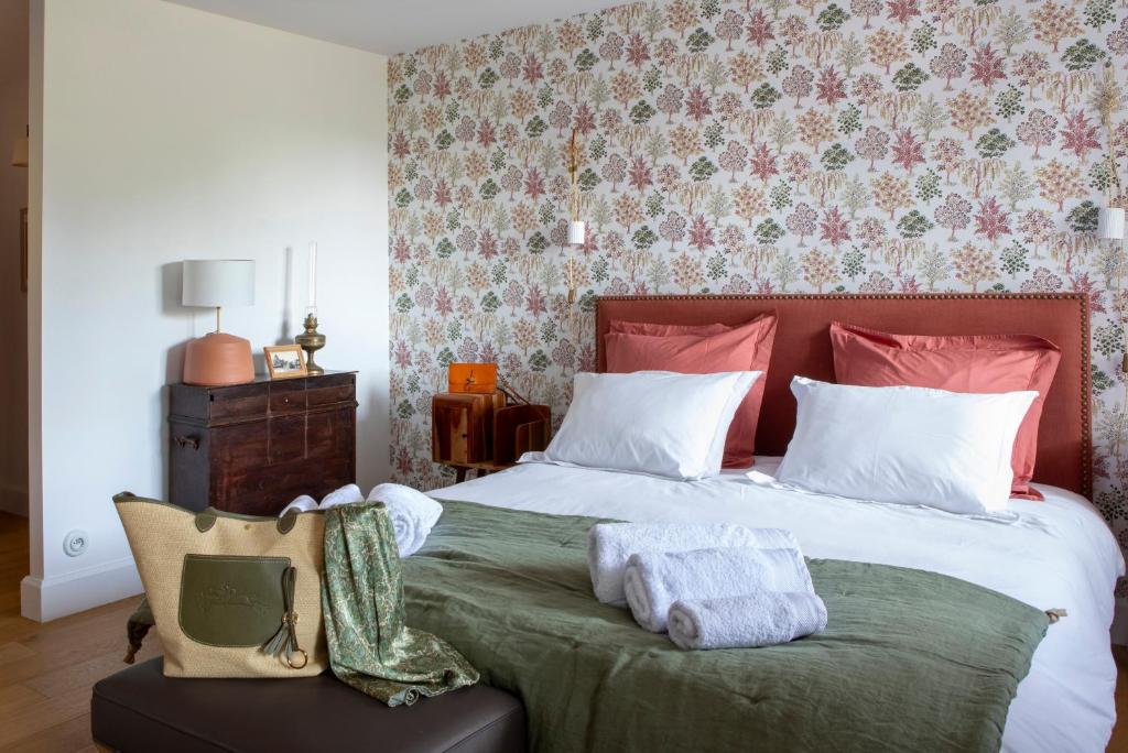 a bedroom with a large bed with a green blanket at Château Montagne "Terre de Sienne" in Saint-Philippe-dʼAiguille