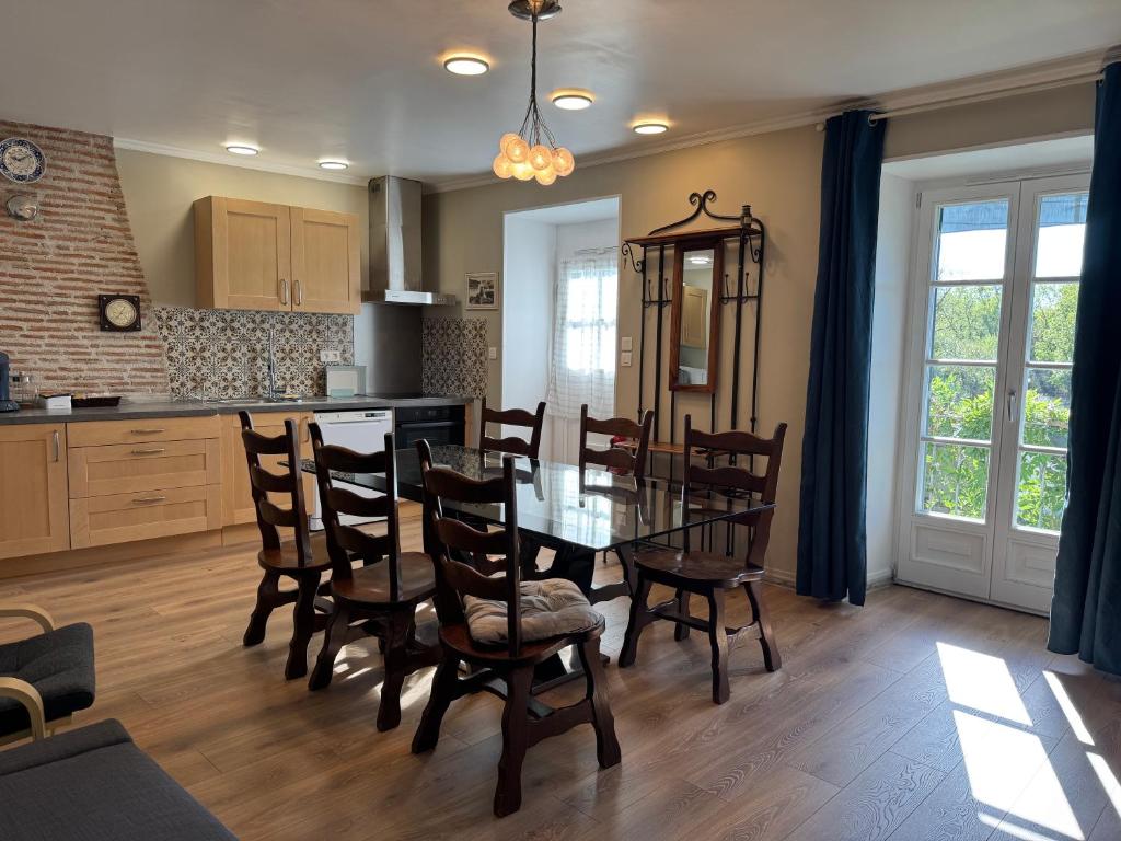 a kitchen and dining room with a table and chairs at Le Lodge de Serenite in Cuffy