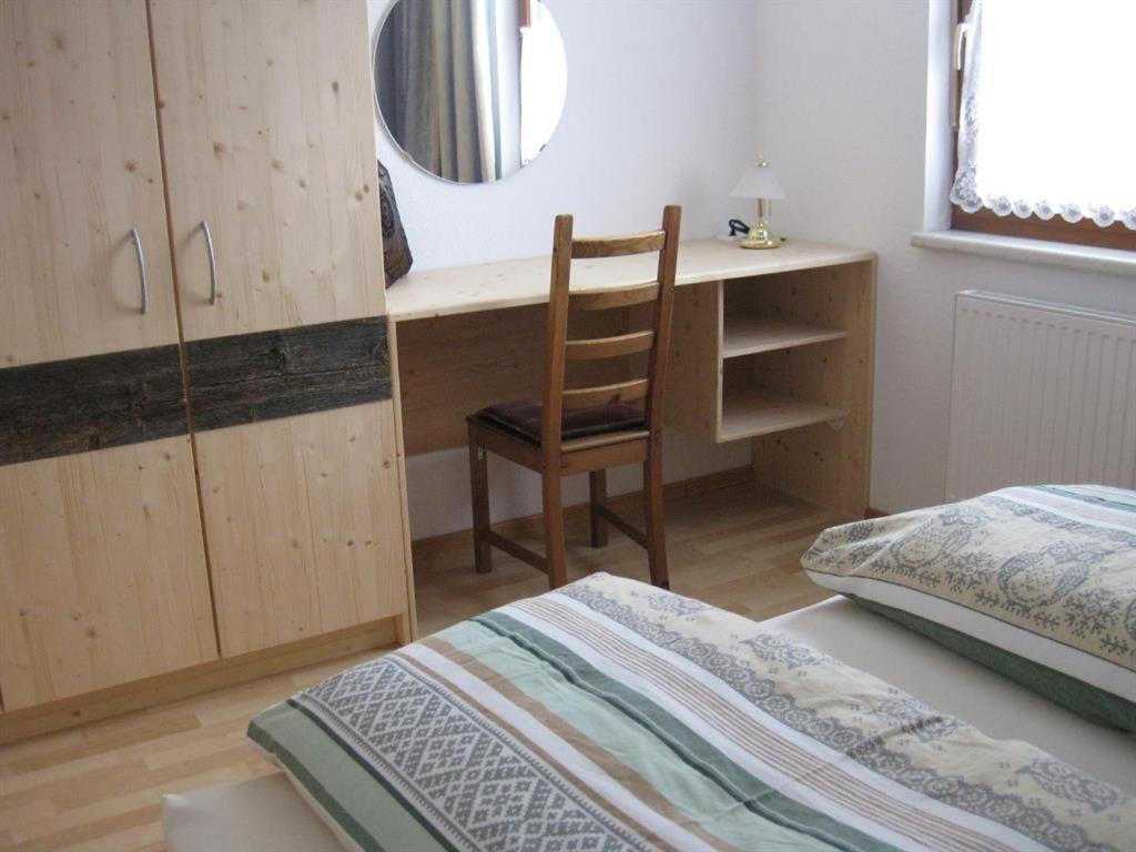 a bedroom with a bed and a desk and a chair at Gästehaus Kerber in Steeg