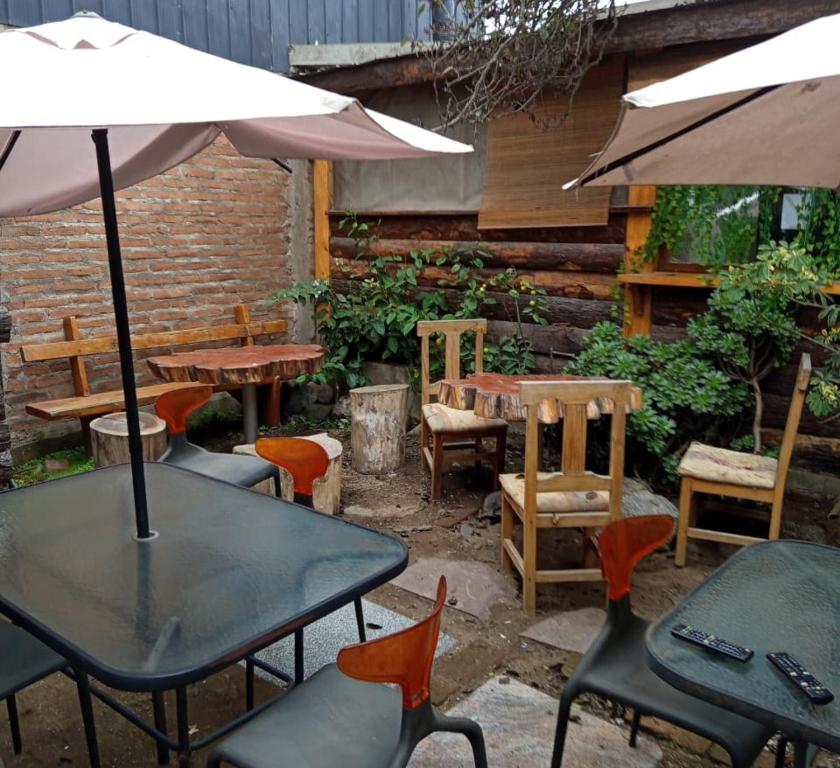 an outdoor patio with tables and chairs and an umbrella at HOSTEL SAKAR QUINTERO Beach in Quintero