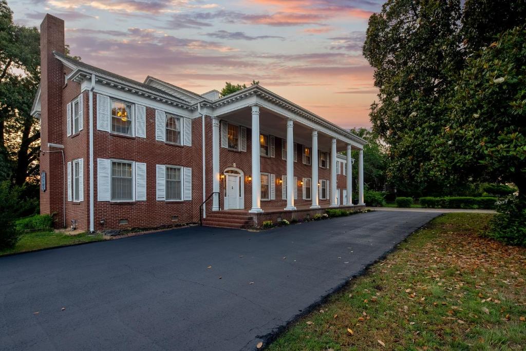 a large brick house with a driveway in front at 6 Private Suites! Game Room, Living Room-The Beland Mansion in Fort Smith