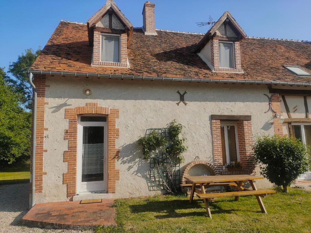a house with a picnic table in front of it at 1 2 3 Sologne - La Nigaudière in Lassay-sur-Croisne