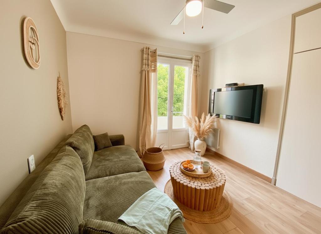 un soggiorno con un divano e una TV di Maison 2 chambres à la plage avec jardin a Canet-en-Roussillon