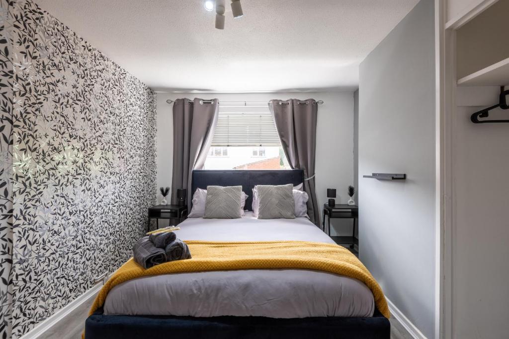 a bedroom with a bed with a yellow blanket on it at Bright 3br Home In Central Belfast in Belfast