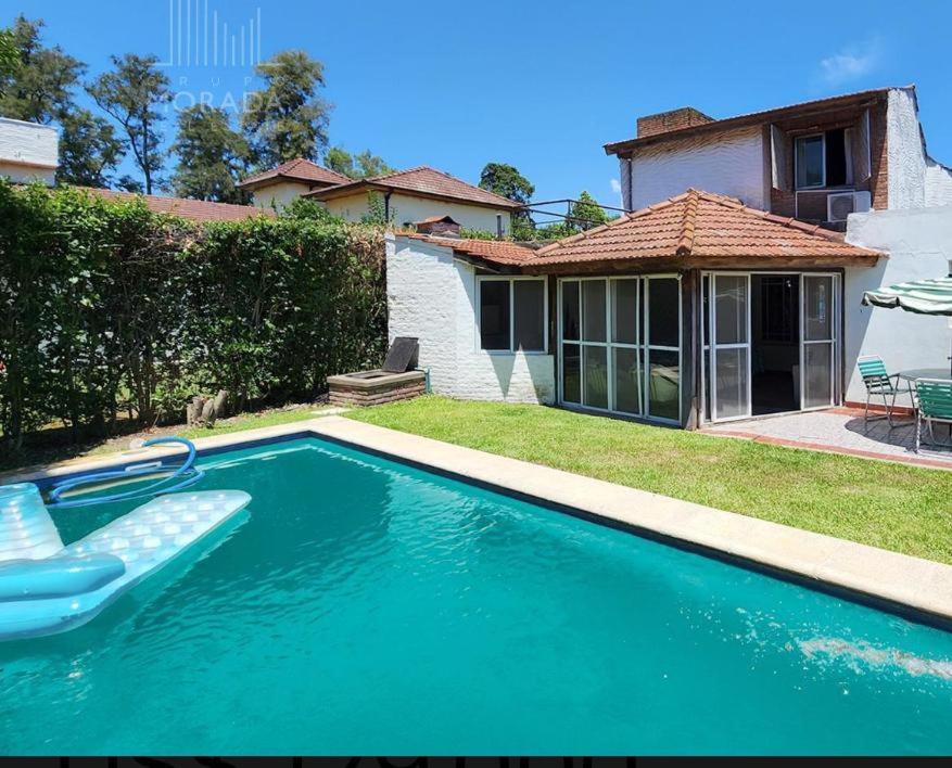 a swimming pool in front of a house at La Cascada Country Club in Pilar