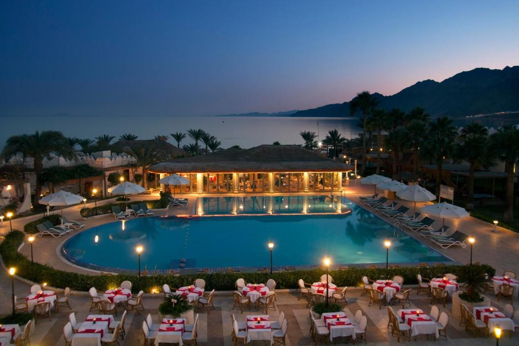 vista para uma piscina num resort à noite em Swiss Inn Resort Dahab em Dahab