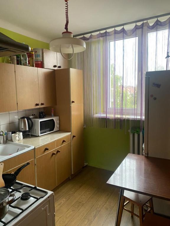 a kitchen with a stove and a microwave at Katedralna 3a apartment in Chełm