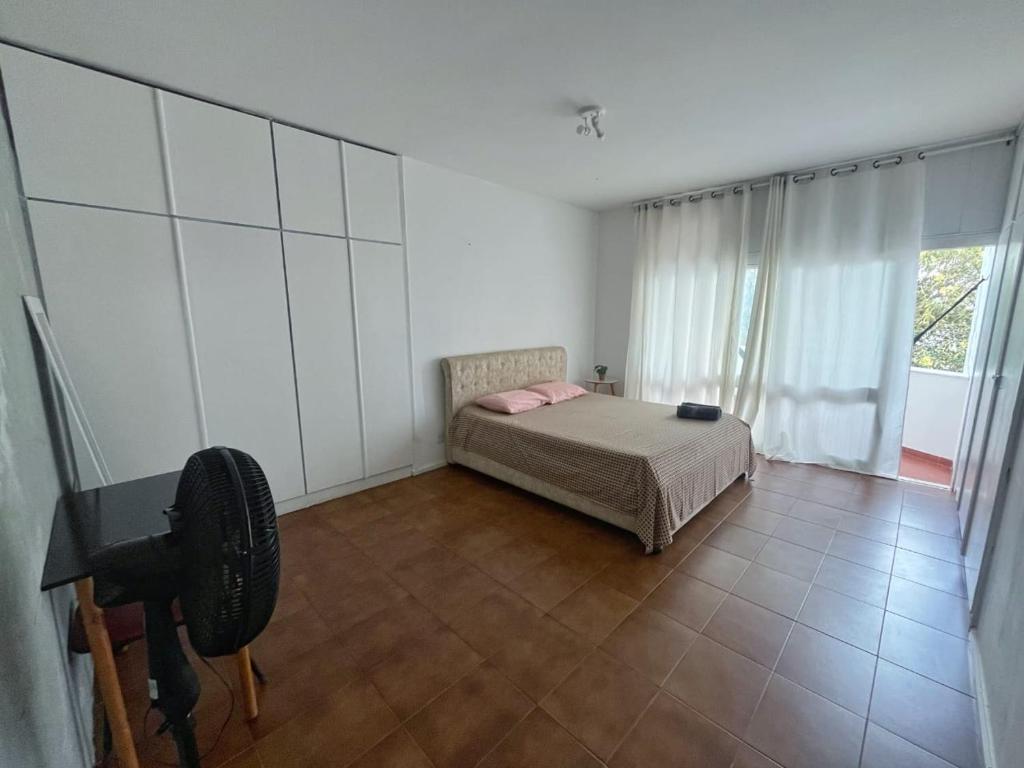 Giường trong phòng chung tại Quarto com Banheiro e Varanda Privados 150m do Mar 4